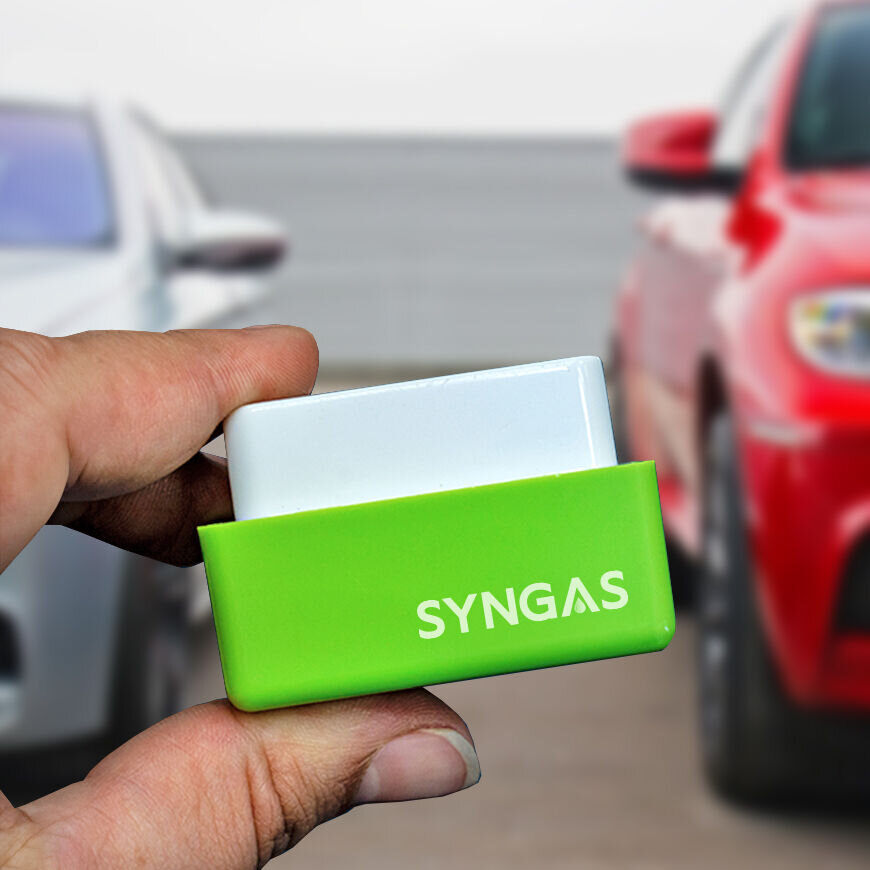 SynGas OBD2-Stecker in der Hand vor Autos